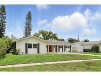Charming single-story home with well-maintained lawn, classic shutters, and red front door at 4611 Cranston Pl, Orlando, FL 32812