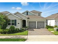 Charming single-Gathering home featuring a two-car garage, brick driveway, and beautifully landscaped front yard at 5314 Golden Apple Dr, Winter Garden, FL 34787