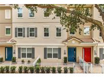 Charming townhouse exterior featuring neutral paint, grey shutters, and colorful front doors at 661 Hangnest Ln, Lake Mary, FL 32746