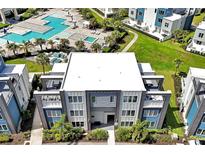 A modern condo building overlooks a luxurious pool area with lush landscaping and contemporary architecture at 7770 Sandy Ridge Dr # 117, Reunion, FL 34747