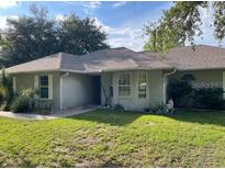 Cozy single-story home features well-manicured lawn, mature trees and simple landscaping at 824 Berryhill Cir, Fruitland Park, FL 34731