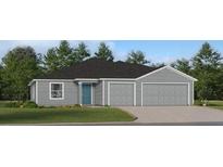 Charming one-story home with a two-car garage, a teal front door, gray siding and a manicured lawn at 8380 Sw 41St Ter, Ocala, FL 34476