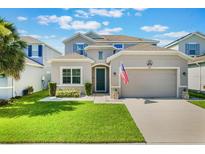 Charming two-story home featuring a well-manicured lawn, inviting curb appeal, and an attached two-car garage at 965 Maypole Dr, Apopka, FL 32703