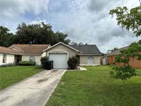 Charming single-story home featuring a well-maintained lawn, driveway, and an attached one-car garage at 9923 Dean Acre Dr, Orlando, FL 32825