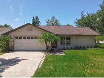 Charming single-story home with a well-maintained lawn, a two-car garage and mature trees at 10018 Chesham Dr, Orlando, FL 32817