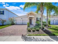 Charming single-story home featuring a brick driveway, stone accents, and mature landscaping at 10091 Lovegrass Ln, Orlando, FL 32832