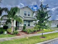 Charming two-story home with stone accents and inviting landscaping, including mature palms at 11070 Longleaf Woods Dr, Orlando, FL 32832