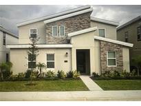 Modern two-story home with a stone facade and well-maintained landscaping at 1201 Challenge Dr, Davenport, FL 33896