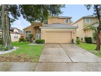 Two-story home with a beige exterior, well-manicured lawn, and a two-car garage at 1400 Holly Glen Run, Apopka, FL 32703