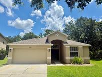 Charming one-story home features a well-maintained lawn and a two-car garage at 14715 Buckingham Gate Ct, Orlando, FL 32828