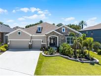 Beautiful single-Gathering home with a manicured lawn, stone accents, and a spacious three-car garage at 17290 Hickory Wind Dr, Clermont, FL 34711