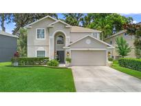 Traditional two-story home with a well-manicured lawn, beautiful landscaping, and an attached two-car garage at 1785 Rushden Dr, Ocoee, FL 34761
