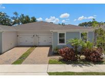 Charming home showcasing a two-car garage, brick driveway, and colorful landscaping at 1841 Overcup Ave, St Cloud, FL 34769