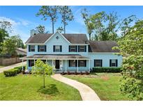 Charming two-story home with a covered front porch and well-manicured lawn at 201 Garden Ln, Longwood, FL 32750