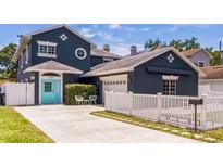 Charming two-story home features a blue exterior with a manicured lawn and white picket fence at 2604 Marble Ave, Orlando, FL 32803