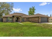 Charming brick home featuring an arched entryway, a two-car garage, and lovely curb appeal at 3 Pine Glen Dr, Debary, FL 32713