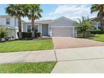 Charming single-Gathering home with a well-manicured lawn, a two-car garage and a brick paver driveway at 3142 Hill Point St, Minneola, FL 34715