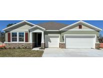 Charming single-Gathering home with a two-car garage and stone accents on the facade at 3305 Arch Ave, Ormond Beach, FL 32174