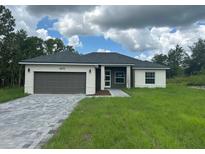 Charming single-story home featuring a two-car garage, neutral paint scheme, and meticulously landscaped front yard at 4572 Sw 149Th St, Ocala, FL 34473