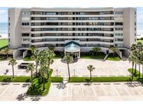 Multi-story condominium featuring a covered entryway, lush landscaping and ample parking at 4631 S Atlantic Ave # 8102, Port Orange, FL 32127