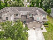 An aerial view of a two-story townhome showcasing a two-car garage and well-maintained landscaping at 533 Mount Olympus Blvd, New Smyrna Beach, FL 32168