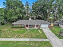 Charming one-story home features a spacious lawn, two-car garage, and red front door at 5460 Se 28Th St, Ocala, FL 34480