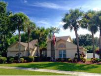 Charming single-Gathering home with a well-manicured lawn, palm trees, and an American flag at 5704 Bay Side Dr, Orlando, FL 32819