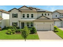 Charming two-story home with a well-manicured lawn, lush landscaping, and a two-car garage at 7613 Wandering Way, Orlando, FL 32836