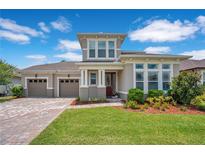 Beautiful two-story home with a well-manicured lawn and a three-car garage at 9426 Launch Point Rd, Orlando, FL 32832