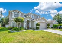 Charming two-story home with landscaped yard and attached two-car garage under a sunny blue sky at 9846 Palmetto Dunes Ct, Orlando, FL 32832