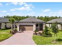 Charming single-story home with a paver driveway and two-car garage at 1388 Lombardi Ct, Kissimmee, FL 34759