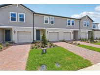 Attractive townhomes boast well-maintained landscaping and brick driveways for enhanced curb appeal at 16390 Bird Of Paradise Ave, Clermont, FL 34714