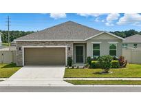 Charming single-story home featuring a stone facade, attached garage, and well-manicured lawn at 24401 Sunnys Halo Way, Sorrento, FL 32776