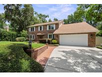 Charming two-story brick home boasts a manicured front yard and attached two-car garage at 2592 Westminster Ter, Oviedo, FL 32765