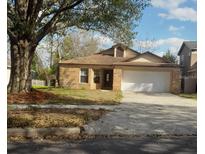 Charming brick home with a two-car garage and well-maintained front yard at 3013 Barrymore Ct, Orlando, FL 32835