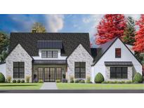 Charming two-story home with gray brick, black framed windows, manicured lawn and beautifully landscaped front yard at 4343 Juliana Lake Dr, Auburndale, FL 33823