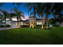 Charming home featuring well-maintained landscaping, lush green lawn, and mature palm trees at 4934 Legacy Oaks Dr, Orlando, FL 32839