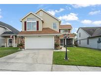 Inviting two-story home featuring a well-maintained lawn and attached two car garage with beautiful stone accents at 5365 Rocking Horse Pl, Oviedo, FL 32765