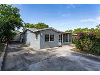 Charming single-story home with a concrete driveway, grey exterior, and a screened-in porch perfect for relaxing at 540 W Columbia St, Lake Alfred, FL 33850