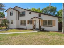 Charming two-story home featuring neutral paint, a well-maintained lawn and inviting front porch at 5420 Lido St, Orlando, FL 32807