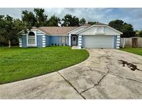 Charming single-story home with well-maintained lawn, attached two-car garage, and blue and white color scheme at 6026 Canyon De Chelley Ct, Orlando, FL 32810