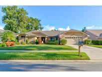 Charming single-story home with manicured lawn, mature trees, and an attached two-car garage at 680 Cheoy Lee Cir, Winter Springs, FL 32708
