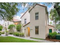 Exterior of a two-story home featuring a red tile roof and beige stucco walls, surrounded by lush landscaping at 710 Siena Palm Dr # 104, Celebration, FL 34747