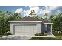 Charming single-story home featuring a large garage and well-maintained landscaping at 7412 Sandstone Dr, Groveland, FL 34736