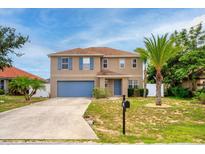 Two-story home with blue shutters, a blue front door, and a well-maintained front lawn at 1033 Sabine Pl, Kissimmee, FL 34759