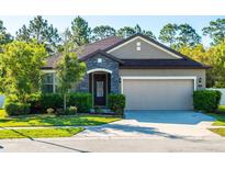Charming single-story home with stone accents, manicured landscaping, and an attached two-car garage at 113 San Mardeen Ct, Daytona Beach, FL 32117