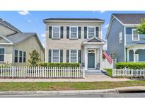 Charming two-story home featuring a white picket fence and an inviting covered front porch at 183 Longview Ave, Kissimmee, FL 34747