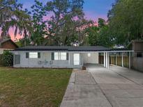 Charming single-story home with a covered front porch and driveway, surrounded by lush landscaping at 235 Ruth Blvd, Longwood, FL 32750
