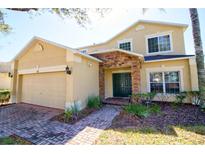 Charming two-story home with a two car garage, stone accents, and well-maintained landscaping at 331 Bridgewater Dr, Davenport, FL 33897