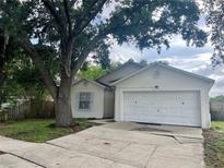 Charming single-story home with a large tree, attached garage, and well-maintained lawn at 4714 Robbins Ave, Orlando, FL 32808
